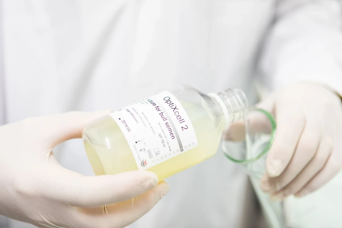 Manipulation d’un flacon avec des gants au laboratoire