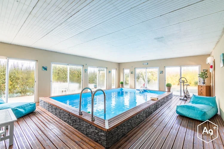 Piscine intérieure ouverte sur le jardin