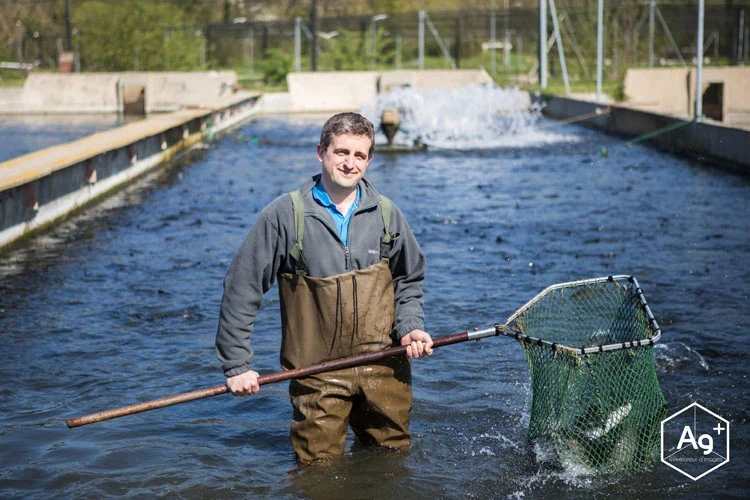 Producteur dans les bassins de sa pisciculture