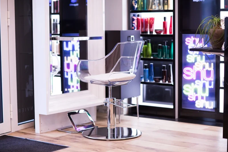 Fauteuil de coiffure devant les étagères de produits