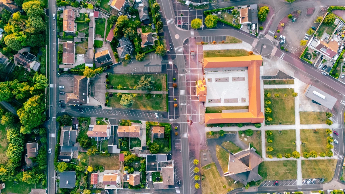 Vue verticale de Giberville montrant des bâtiments aux toits rouges, des rues, des maisons et des espaces verts.