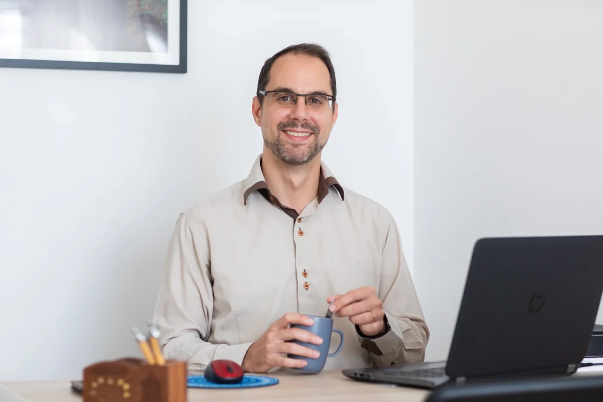 Thierry Langou, hypnothérapeute, assis dans son cabinet, souriant, une tasse dans les mains.